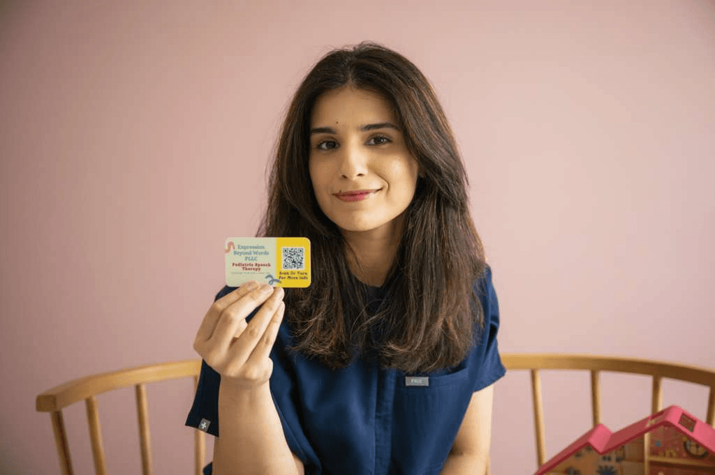 Verda holding an Expression Beyond Words business card